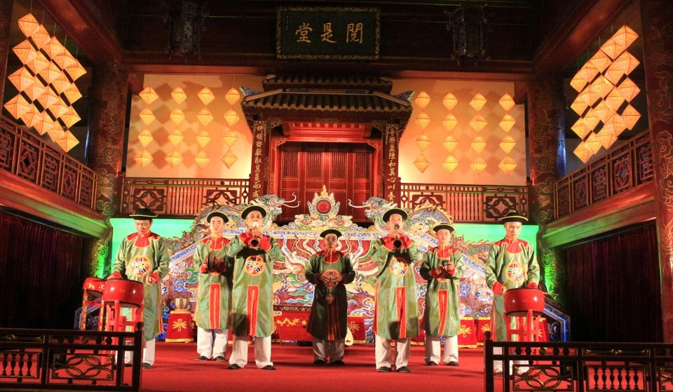 A performance of Hue Royal Court Music on a boat along the Huong River, showcasing traditional musicians in royal attire.