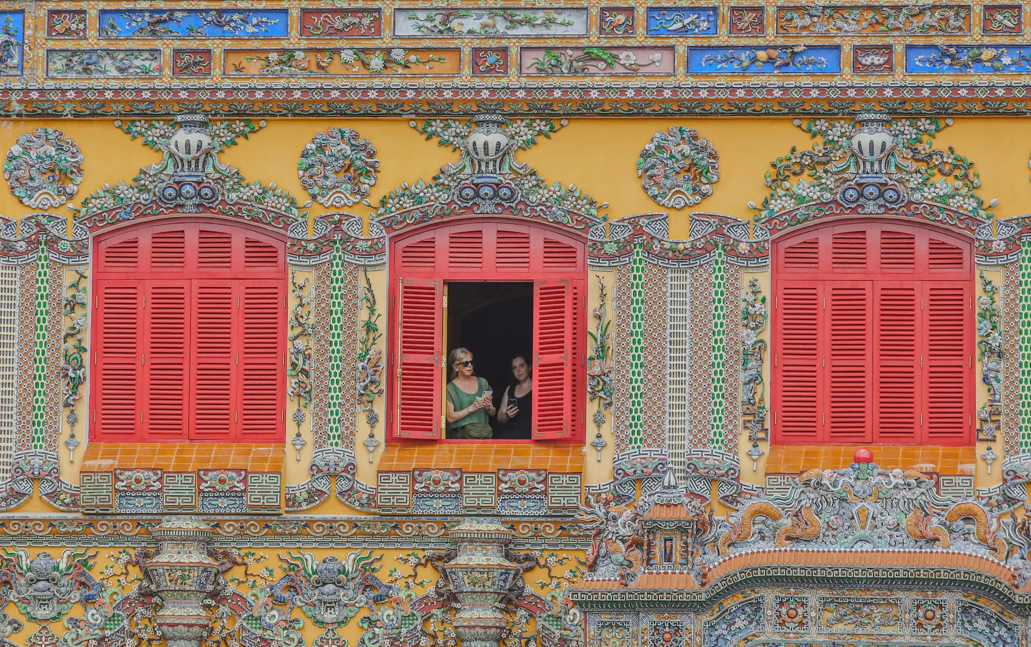 Detailed view of the porcelain mosaics and dragon motifs on the front façade of Kien Trung Palace in Hue.