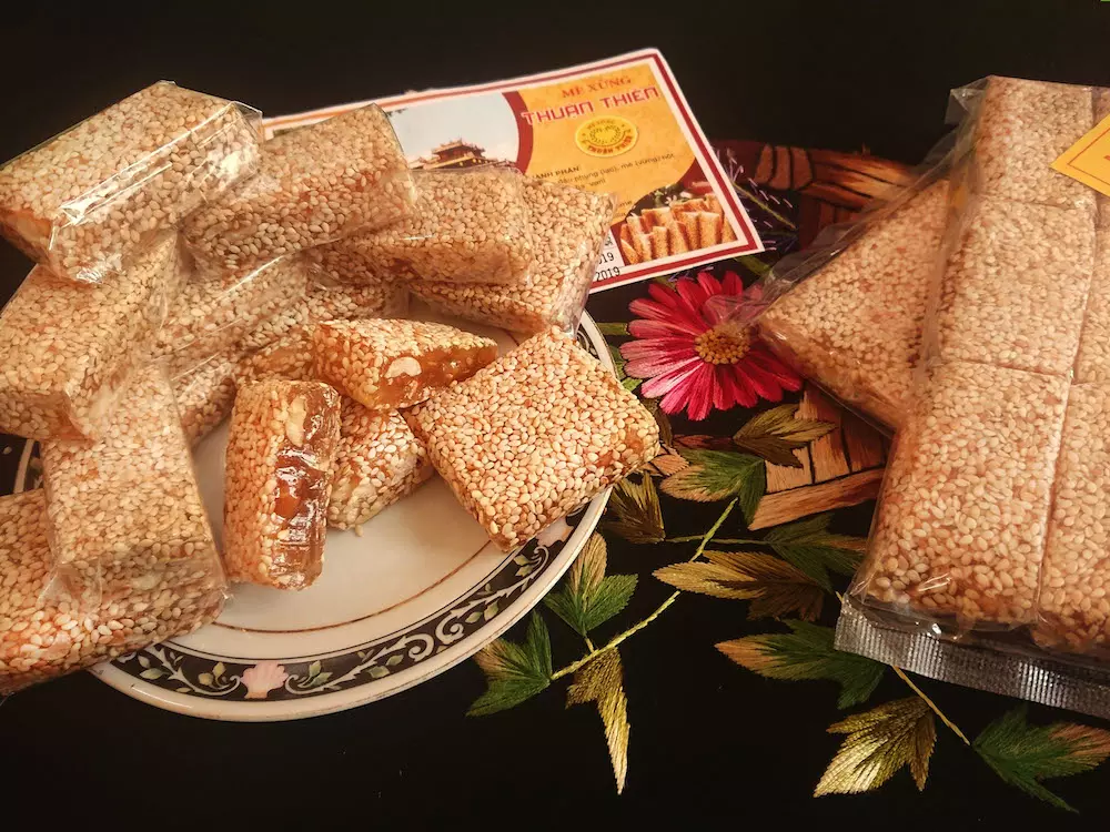 A close-up of Me Xung (Hue Sesame Candy), highlighting its chewy texture and peanut filling.