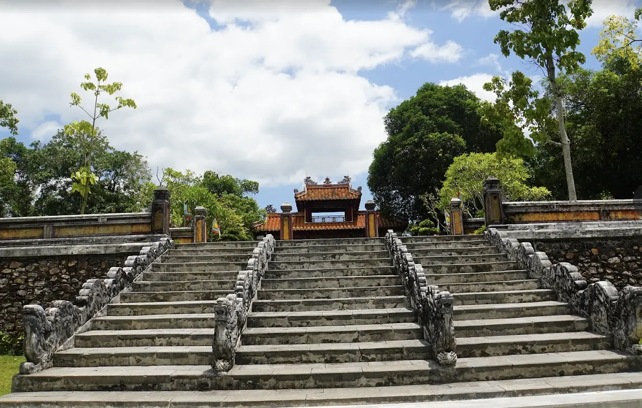 Tomb of Gia Long on Thien Tho Mountain in Hue with pine trees, lotus ponds, and scenic surroundings.