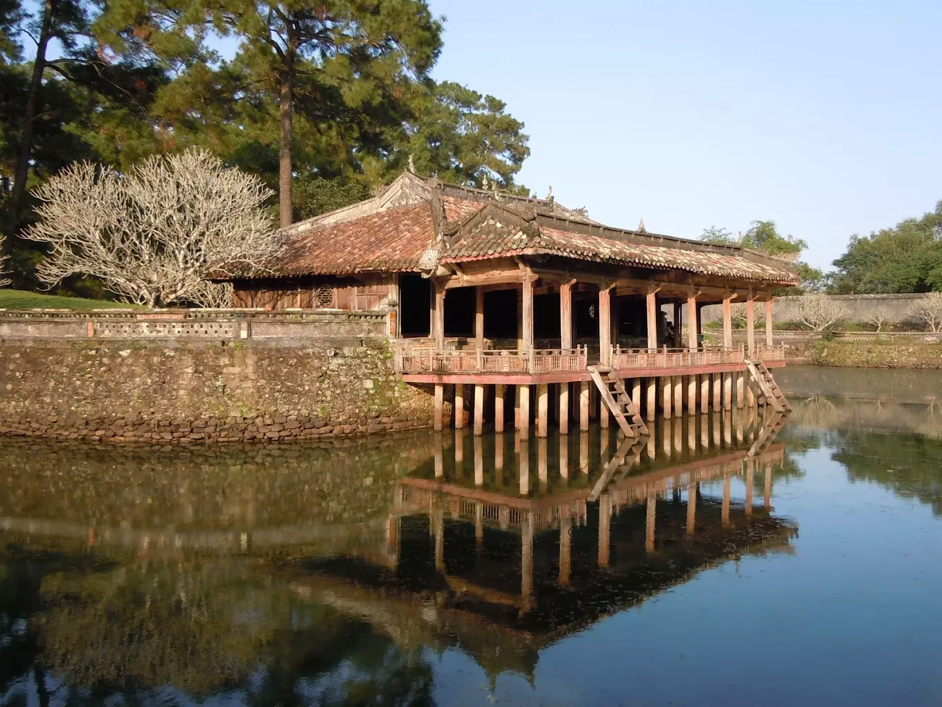 Tomb of Minh Mang in Hue with tranquil ponds, lush greenery, and scenic mountain backdrop.