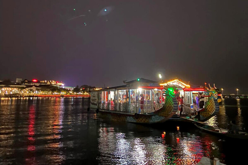 Nighttime view of dragon boats on the Huong River in Hue under the full moon.