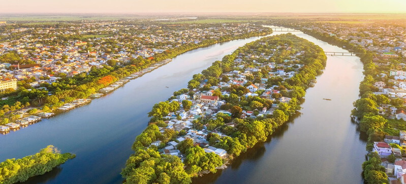 Huong River in Hue, Vietnam, with clear blue water and picturesque countryside.