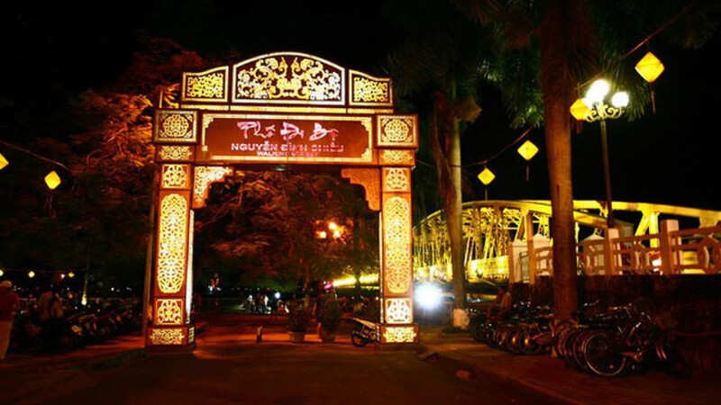 Nguyen Dinh Chieu Pedestrian Street illuminated at night, with views of the Huong River and Truong Tien Bridge.